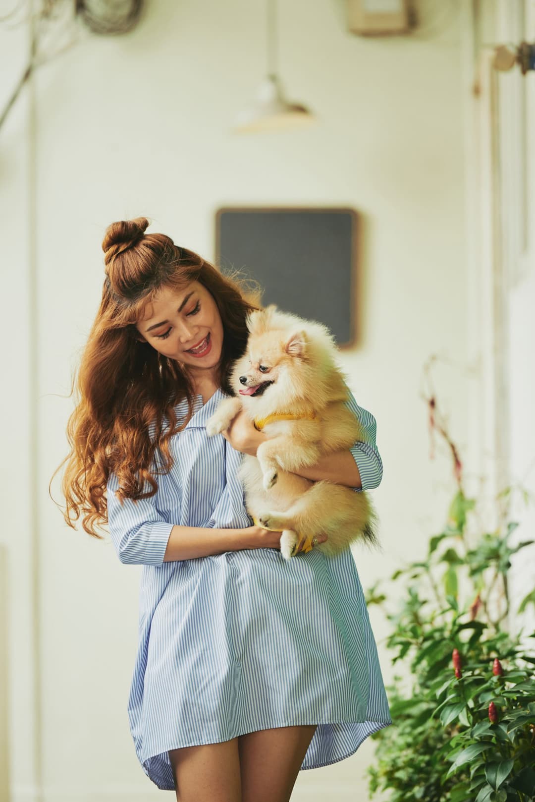 A woman happily holding her pomeranian