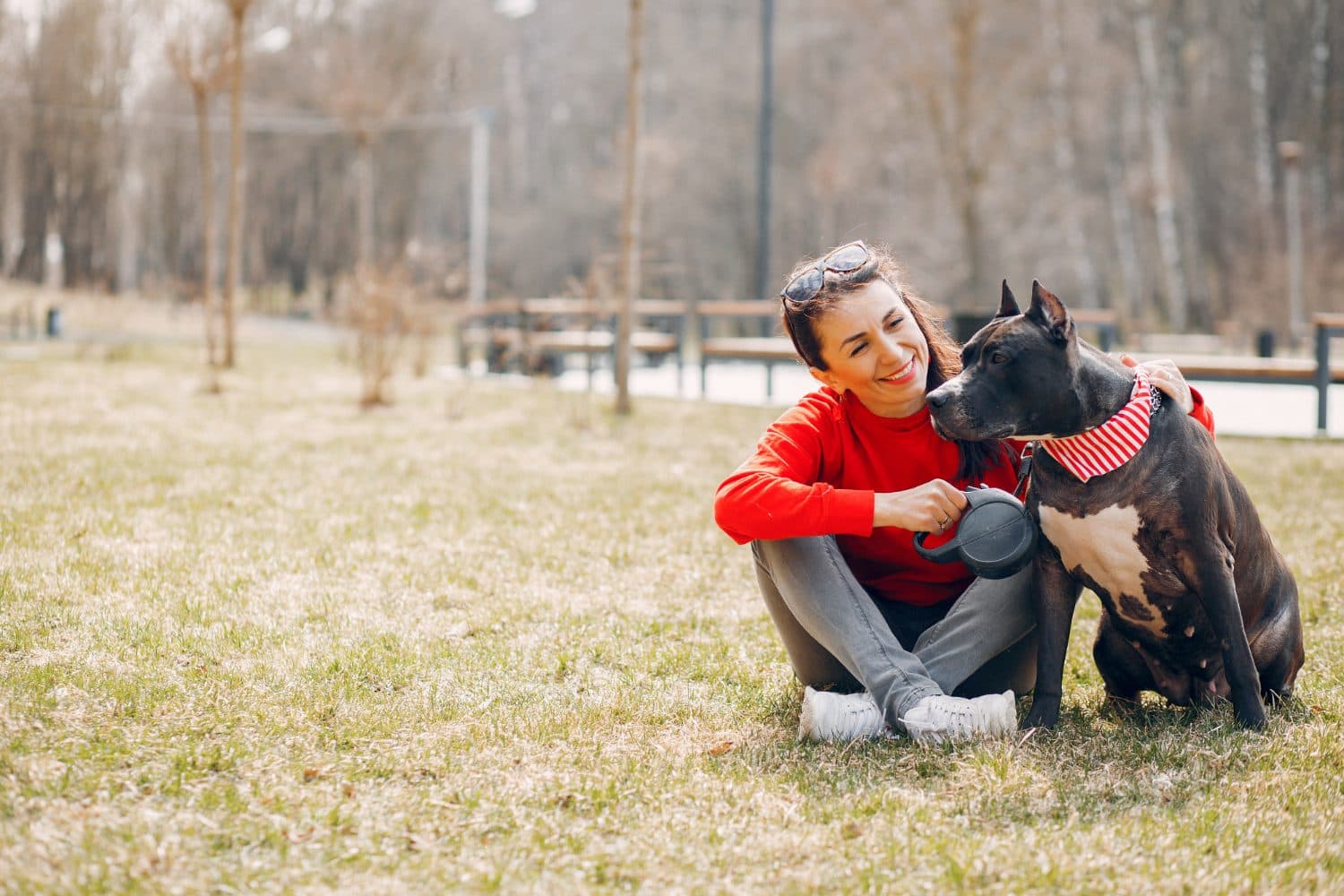 A man sitting with his rescued dog in a park